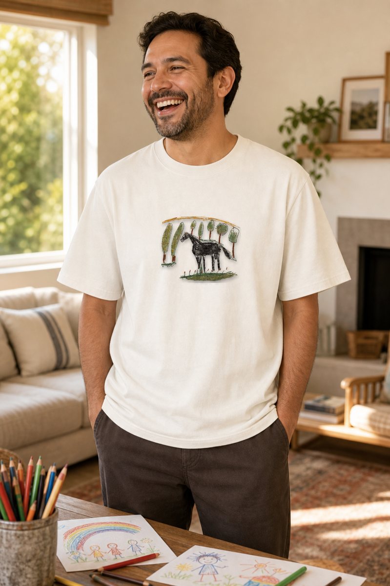 A laughing dad wearing a tee with his kid's horse drawing embroidered on it