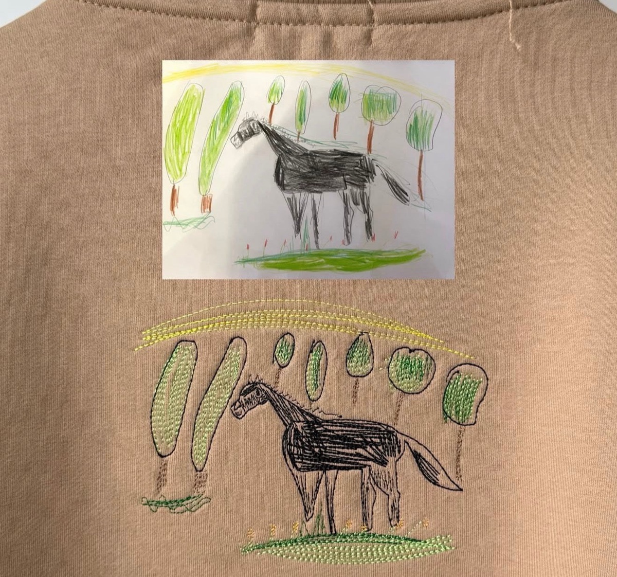 A child's horse drawing embroidered on a tee, photographed in the shop